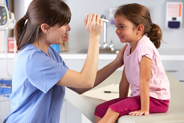 Doctor examining girl's eyes